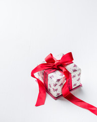 Gift box with red bow ribbon and sweet candy hearts on white wooden table. Beautiful Valentines day background. Romantic mood.) 