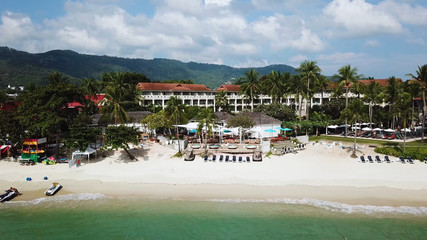 Top View of Paradise Beach. Beautiful tropical island with sand beach, palm trees. Aerial view of tropical beach on the island. Tropical landscape: beach with palm trees. Seascape: Ocean, sky, sea