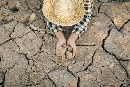Asian man on cracked dry ground, concept drought and crisis environment