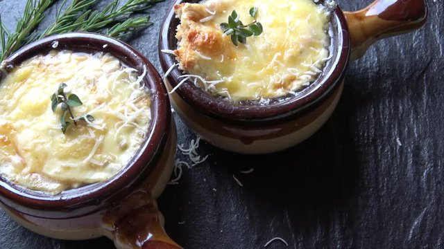 Grating Parmesan Cheese onto bowls of delicious french onion soup.