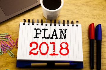 Hand writing text caption showing Plan 2018. Business concept for Planning Strategy Action Plan written on notebook book on the wooden background in the Office with laptop coffee