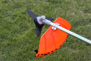 Brush cutter metal knife in green grass