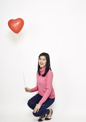 Young woman holding a red balloon