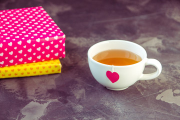 Cup of tea with heart teabag and gift boxes
