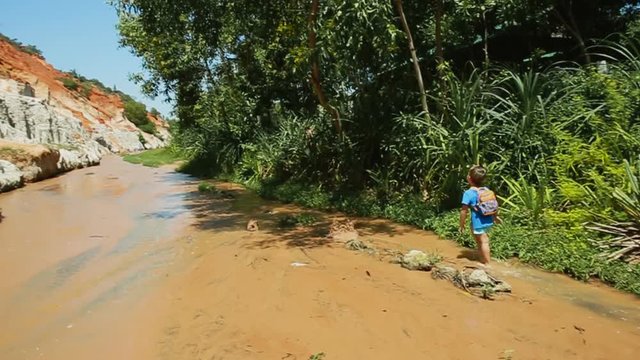 Kid traveler walking at Fairy Stream (Suoi Tien), the travel place in Muine, Vietnam
