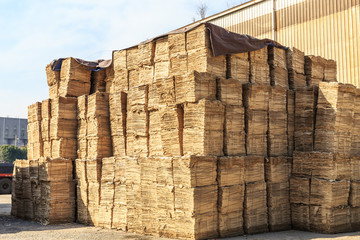 many cardboard raw materials are stacked in the factory's outdoor warehouse