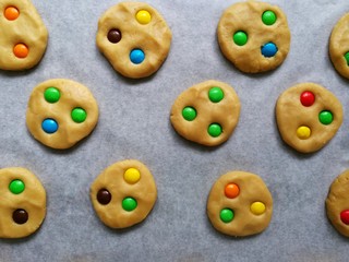 baking cookies with colorful candy m&m in the kitchen , on a wooden table 