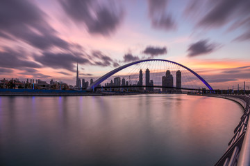Fototapeta na wymiar Long exposure of stunning sunrise colors over Dubai Downtown and Dubai Water Canal. Dubai, UAE.