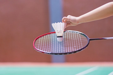 kid holding badminton racket and shuttlecock  in badminton court