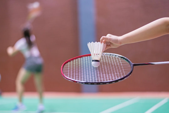 kid holding badminton racket and shuttlecock  in badminton court