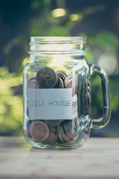 Concept of saving money in a jar on a house.