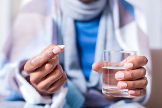 Doctors prescription. Selective focus of a glass with water and a pill being in hands of a nice ill man