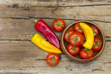 tomatoes and peppers on wooden background