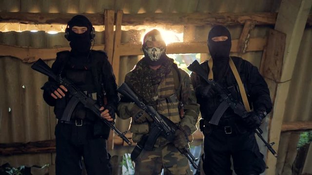 SWAT officers hold rifles on slings close to their chests. 