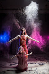 Young mother and small daughter during photoshoot with flour