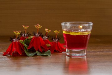 Red Passion Flower and Water Candle /Water Candle in Glass and Red Passion Flower on Brown Wood Flooring adds romance.