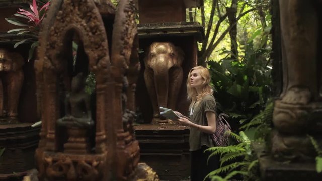 woman tourist with a map walks in a park Bali