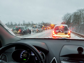snowstorm, poor car driving on slick roads