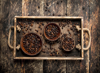 Coffee beans in bowls on a tray.