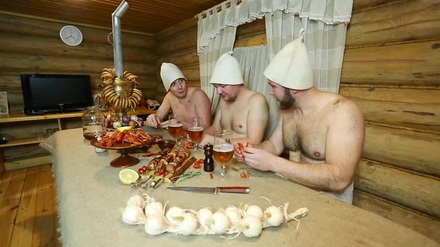 friends relax in the Russian sauna and drink beer