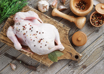 chicken carcass on a wooden background with spices, cooking in the kitchen, rustic style