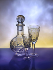 Crystal decanter and wineglasses on colorful background