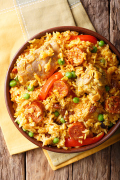 Arroz Valenciana with rabbit, chorizo, vegetables and spices in a bowl. vertical top view