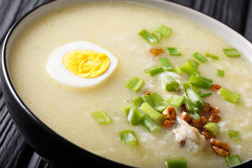 Homemade Asian rice soup with chicken, vegetables and egg close-up. horizontal