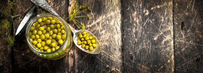 Pickled green peas in glass jar.