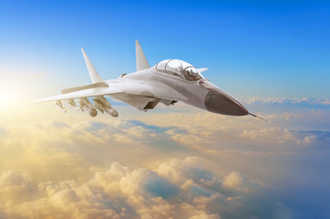 Military fighter aircraft at high speed, flying high in the sky sunset.