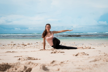Fototapeta na wymiar Woman training yoga on the beach