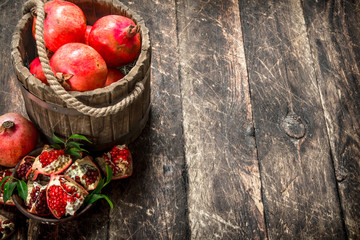 Fresh pomegranates in wooden bucket.