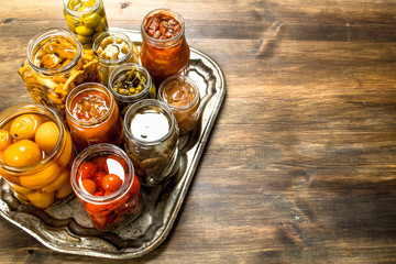 Preserved mushrooms and vegetables on a steel tray.