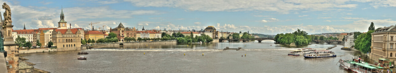 A stitched panoramic view or panorama banner of the Vltava river in Prague, Czech Republic.