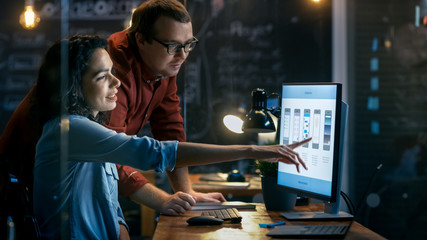 Beautiful Female Mobile Gaming Application Developer Talks With Her Male Colleague, They Discuss Creative Design. Stylishly Lit Office.