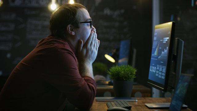 Stressed Financier Hits the Table with His Fist in Frustration and Covers His Face in Hands. He's Working on a Personal Computer with Statistics Showing on the Screen.