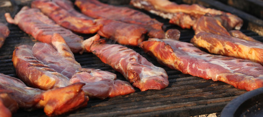 Grilling raw meat. Raw meat prepared on a grill. Fast food outside.  