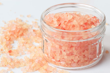 Big Crystals of pink Himalayan salt in jar. White background. Top view. Isolated.