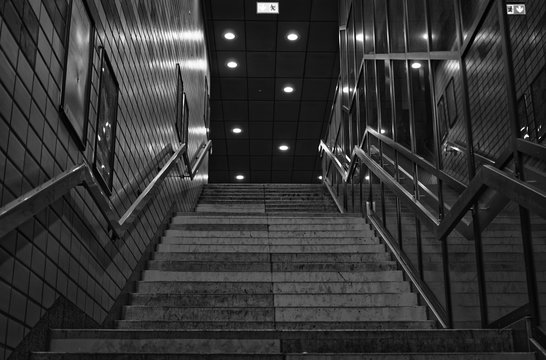 Stairs of the subway station Jungfernstieg in Hamburg in Germany Europe in black and white optics with emergency exit sign