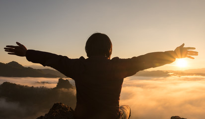 The man stands arms up on the mountain. thanks to God