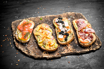 Sandwiches with seafood, meat and vegetables on fresh bread.