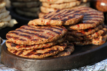 Homemade meatballs on an electrical grill. Grill background. Fast foot outside.  Diet and health. Minced meat on barbecue. Pleskavitsa, pleskavitza, pleskaviza