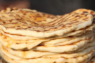 Pita. Pile of roasted pita, baked flat bread. Heap of focaccia bread. Lavash. Purlenka