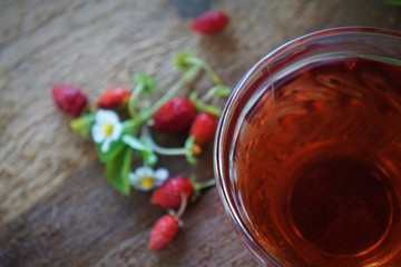 Woodland strawberry tea with fresh berries on wooden background