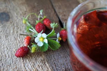 Woodland strawberry tea with fresh berries on wooden background
