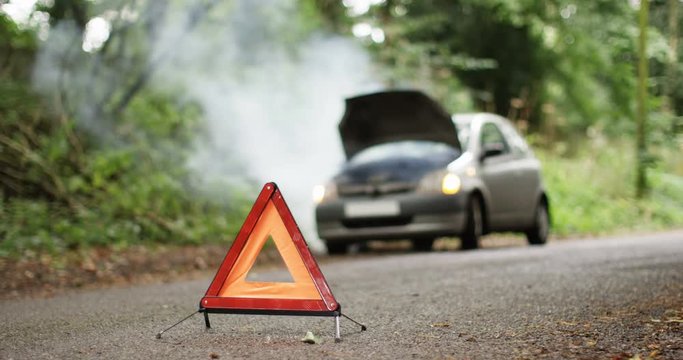 4K Broken down car with smoking engine left abandoned on quiet country road. No people.