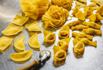 Various kinds of traditional italian really homemade pasta, some stuffed. Tagliatelle, fettuccine, tortelloni, tortellini, ravioli, pappardelle.
