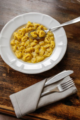 Tortellini with broth. Typical homemade fresh stuffed pasta cooked in broth. Traditional italian festive and christmas food. - obrazy, fototapety, plakaty