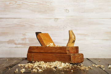 old planer on dark wooden table near white wall