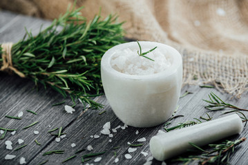 Marble mortar for spices, salt, olive oil and sprigs of rosemary on a wooden cutting board